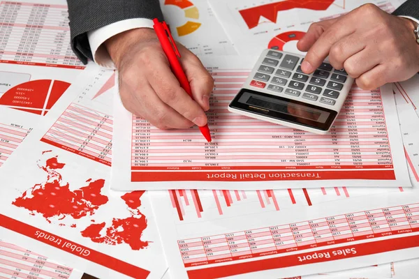 Zakenman accountant met behulp van de calculator voor het berekenen van de financiën op Bureau office. Financiële boekhouding bedrijfsconcept rood rapporten en grafieken. Werknemer op kantoor onderzoekt schema's en verslagen. — Stockfoto