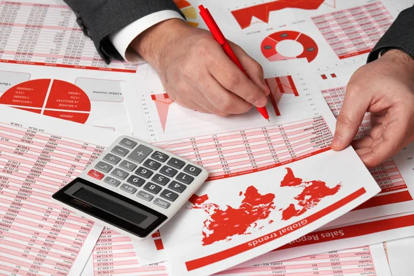 Akuntan pengusaha menggunakan kalkulator untuk menghitung keuangan di kantor meja. Konsep akuntansi keuangan bisnis Laporan merah dan grafik. Pegawai kantor memeriksa jadwal dan laporan . — Stok Foto