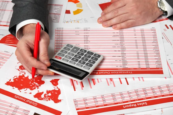 Businessman accountant using calculator for calculating finance on desk office. Business financial accounting concept Red reports and graphs. Office employee examines schedules and reports. — Stock Photo, Image