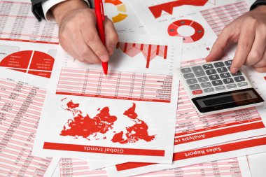 Finans Danışma Office hesaplamak için hesap makinesini kullanarak işadamı muhasebeci. İş finansal muhasebe kavramı kırmızı raporları ve grafikler. Ofis çalışanı tablolarını ve raporları inceler.