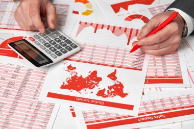 Finans Danışma Office hesaplamak için hesap makinesini kullanarak işadamı muhasebeci. İş finansal muhasebe kavramı kırmızı raporları ve grafikler. Ofis çalışanı tablolarını ve raporları inceler.