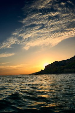 güzel gün batımı, deniz manzara Yalı yüksek tepeler, vahşi doğa ile
