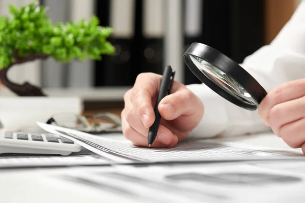 Businessman working in office and calculating finance. Using magnifying glass. Business financial accounting concept. — Stock Photo, Image