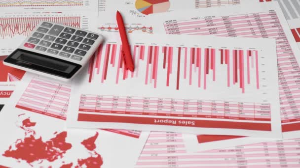 Businessman accountant using calculator for calculating finance on desk office. Business financial accounting concept. Red reports and graphs. Office employee examines schedules and reports.