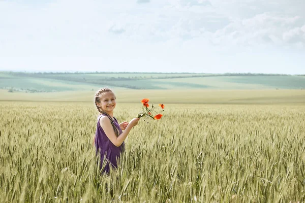 Meisje met rode tulp bloemen poseren in het tarweveld, felle zon, mooie zomerse landschap — Stockfoto