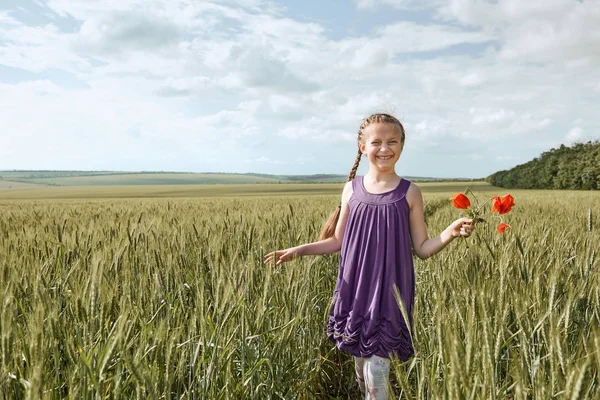 Meisje met rode tulp bloemen poseren in het tarweveld, felle zon, mooie zomerse landschap — Stockfoto