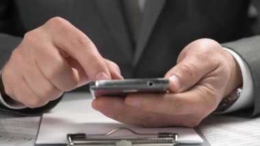 Bir ofiste çalışan ve akıllı telefon kullanan işadamı. İş mali muhasebe kavramı.