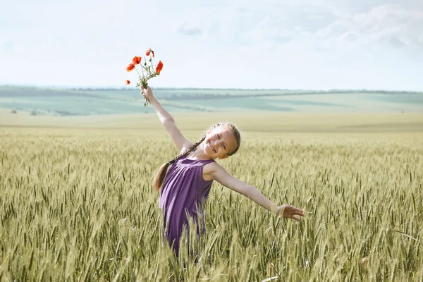 Dívka s červenými Tulipán květy pózuje v pšeničné pole, zářivé slunce, krásné letní krajina — Stock fotografie