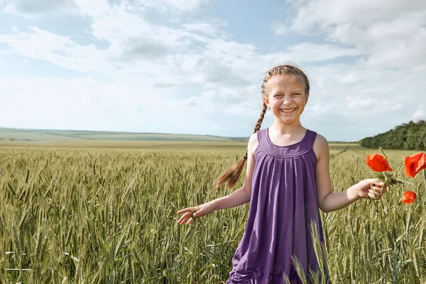 Girl with red tulip flowers posing in the wheat field, bright sun, beautiful summer landscape — Stock Photo, Image