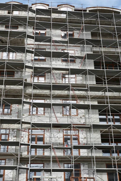 İnşaat, yapı iskeleleri ve beton altında yeni bina — Stok fotoğraf