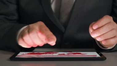 Bir tablet üzerinde çalışan işadamı grafikler ve tablolar çözümler, closeup eller.