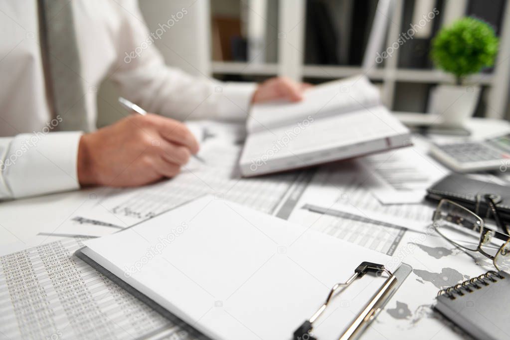 Businessman working at office and calculating finance, reads and writes reports. Business financial accounting concept.