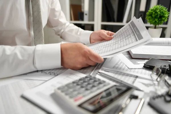 Empresário trabalhando no escritório e calculando finanças, lê e escreve relatórios. Contabilidade financeira das empresas . — Fotografia de Stock