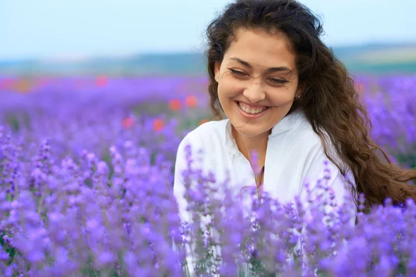 Jovem está no campo de flores de lavanda, bela paisagem de verão — Fotografia de Stock