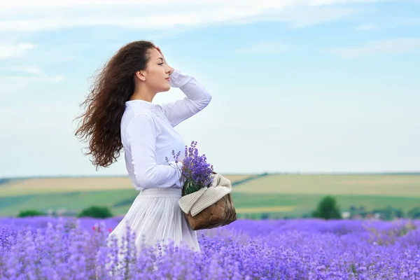 Mladá žena je v levandulově květinové oblasti, krásná letní krajina — Stock fotografie