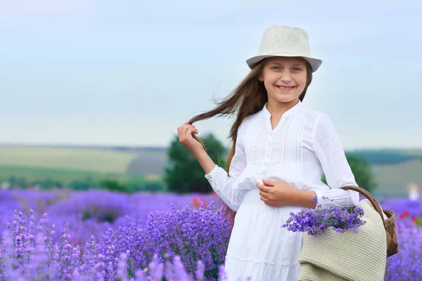 Dívčí dítě je v levandulové květinové oblasti, nádherná letní krajina — Stock fotografie