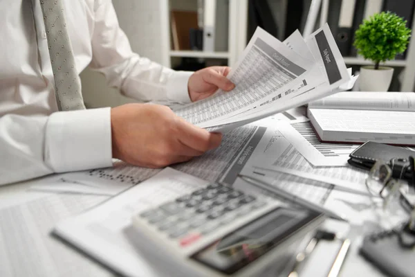 Geschäftsmann, der im Büro arbeitet und Finanzen berechnet, liest und schreibt Berichte. Finanzbuchhaltungskonzept für Unternehmen. — Stockfoto