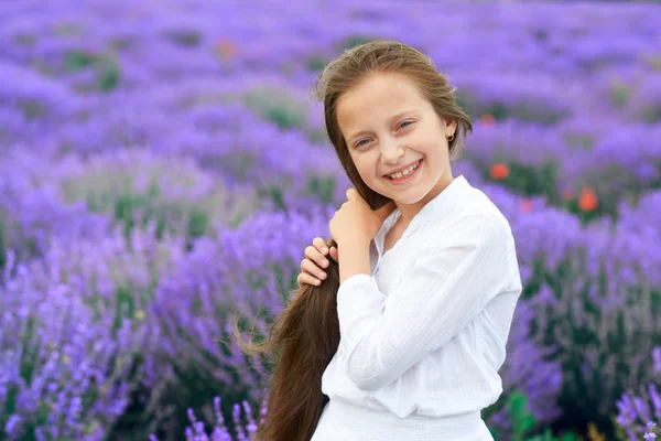 Ragazza bambino è nel campo di fiori di lavanda, bellissimo paesaggio estivo — Foto Stock