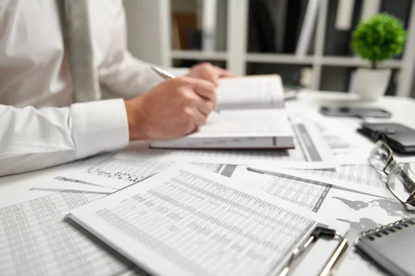 Businessman working at office and calculating finance, reads and writes reports. Business financial accounting concept. — Stock Photo, Image