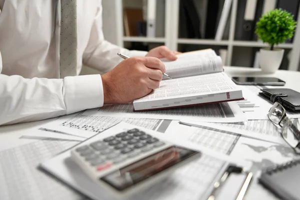 Empresario que trabaja en la oficina y calcula las finanzas, lee y escribe informes. Concepto contable financiero empresarial . — Foto de Stock