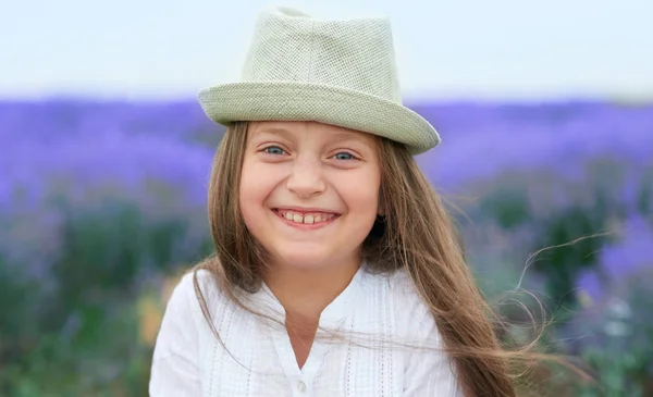 Menina criança está no campo de flores de lavanda, bela paisagem de verão — Fotografia de Stock