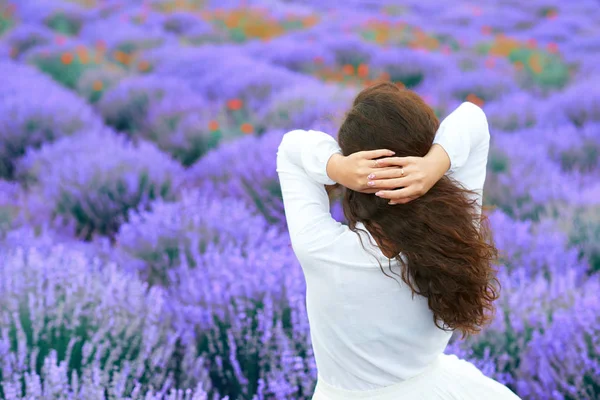 Genç kadın lavanta çiçek alanı, güzel yaz manzara geri duruyor