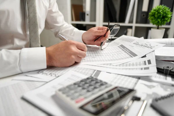 Geschäftsmann, der im Büro arbeitet und Finanzen berechnet, liest und schreibt Berichte. Finanzbuchhaltungskonzept für Unternehmen. — Stockfoto