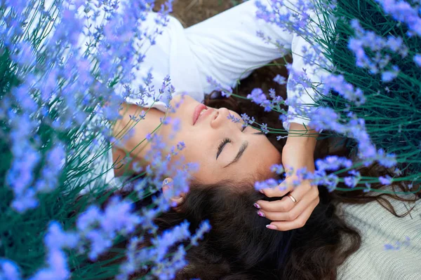 Mujer joven se encuentra en el campo de flores de lavanda, hermoso paisaje de verano — Foto de Stock