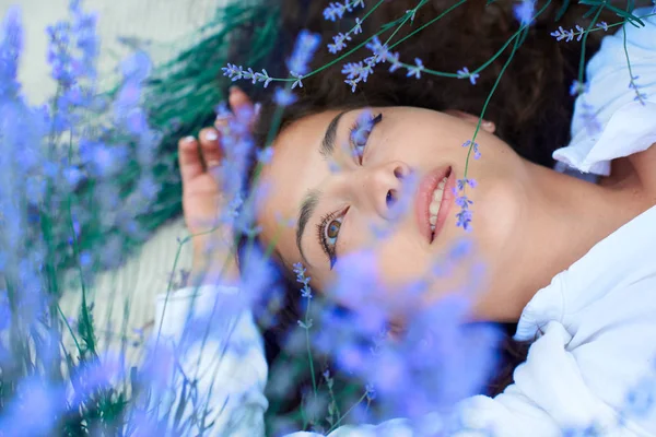 Mladá žena leží v levandulové květinové oblasti, krásná letní krajina — Stock fotografie
