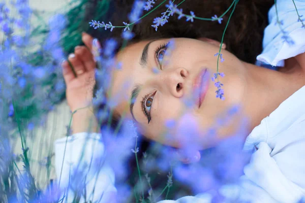 Молода жінка лежить в лавандовому квітковому полі, красивий літній пейзаж — стокове фото