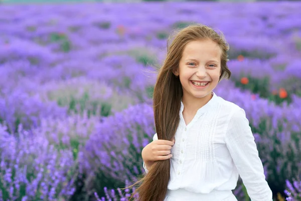 Meisje kind is in de lavendel bloem veld, mooie zomerlandschap — Stockfoto