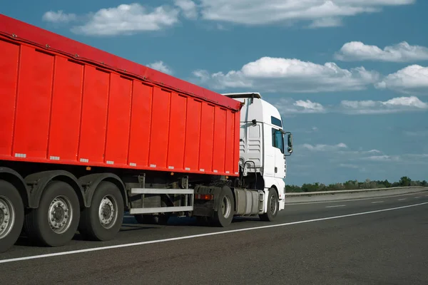 El camión rojo está subiendo por la carretera. Concepto de transporte de carga . — Foto de Stock