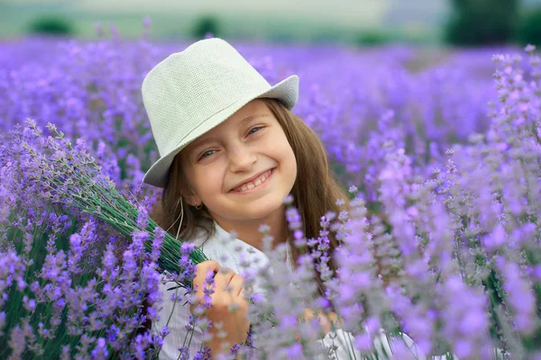 Menina criança está no campo de flores de lavanda, bela paisagem de verão — Fotografia de Stock