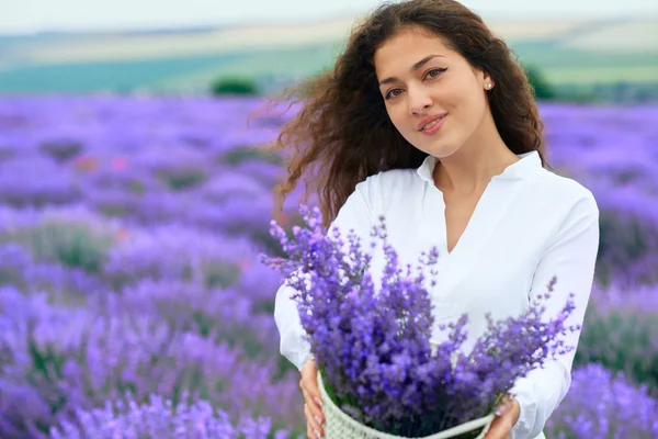 Mladá žena je v levandulově květinové oblasti, krásná letní krajina — Stock fotografie