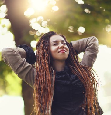 mutlu dreadlocks şık kız güneşli ormanda poz