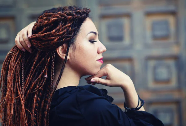 Dreadlocks closeup, fashionable girl posing at old wooden door background — Stock Photo, Image