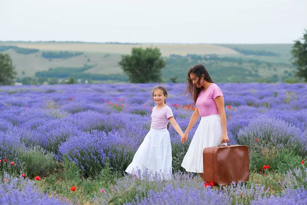 Mladá žena a dívka procházejí levandulovou polní květinou, krásnou letní krajinou — Stock fotografie