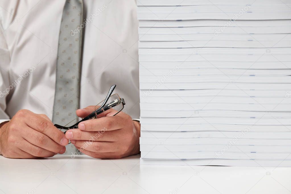 Businessman working at an office, reads stack of books and reports. Business financial accounting concept.