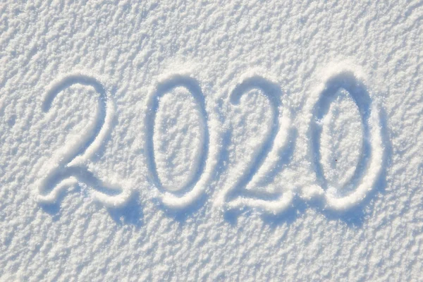 2020 tekst geschreven op sneeuw voor textuur of achtergrond-wintervakantie concept zonnige dag, fel licht met schaduwen, platte lag, bovenaanzicht, schoon en niemand — Stockfoto