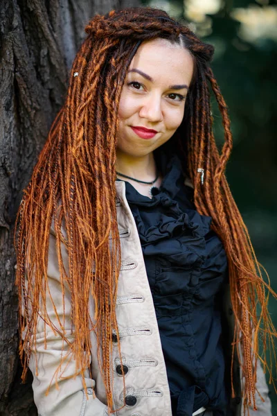 Happy dreadlocks fashionable girl posing in forest — Stock Photo, Image
