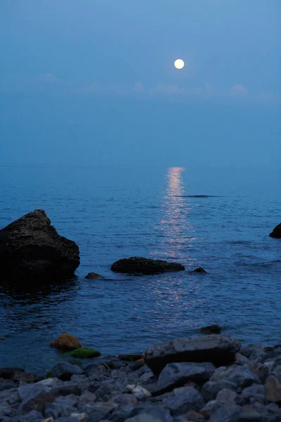 Sea landscape at sunset with moon, stone coast and beautiful sky — Stock Photo, Image
