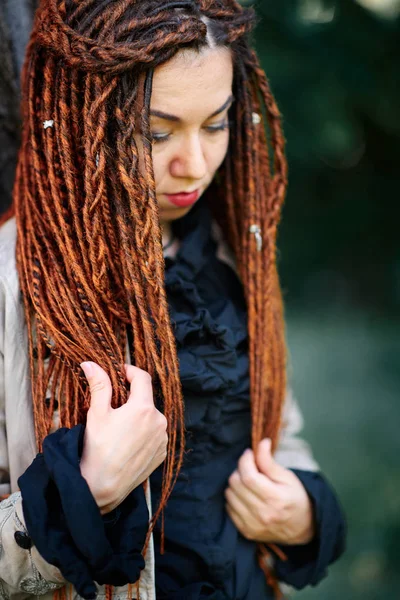 Happy dreadlocks fashionable girl posing in forest — Stock Photo, Image