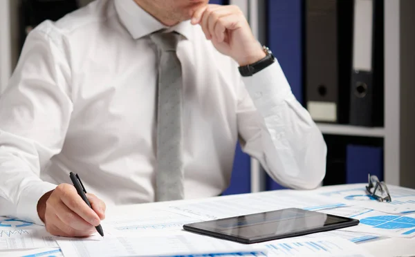 Biznesmen pracujący z tabletem PC, obliczanie, czytanie i pisanie raportów. Pracownik biurowy, zbliżenie tabeli. Koncepcja rachunkowości finansowej firmy. — Zdjęcie stockowe