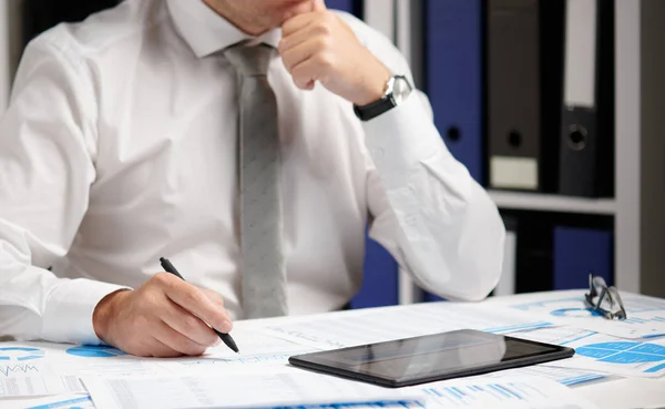 Biznesmen pracujący z tabletem PC, obliczanie, czytanie i pisanie raportów. Pracownik biurowy, zbliżenie tabeli. Koncepcja rachunkowości finansowej firmy. — Zdjęcie stockowe