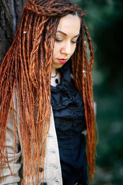 Happy dreadlocks fashionable girl posing in forest — Stock Photo, Image