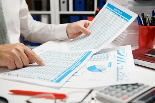 Businessman working and calculating, reads and writes reports. Office employee, table closeup. Business financial accounting concept. Royalty Free Stock Images