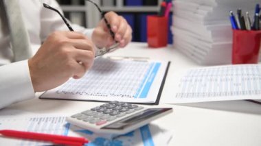 İş adamı çalışma ve hesaplama, okur ve raporlar yazar. Ofis çalışanı, Masa çekim. İş mali muhasebe kavramı.