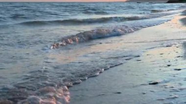 Gün batımında deniz dalgasının yavaş hareketi, kum, plaj - yaz ve seyahat konsepti