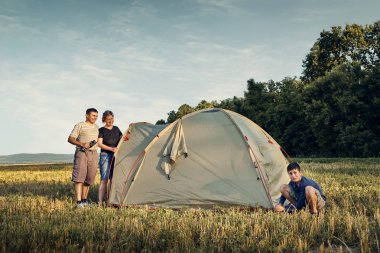 Aile gün batımı, güzel yaz manzara çadır kampı kurmak. Turizm, doğa yürüyüşü ve seyahat.