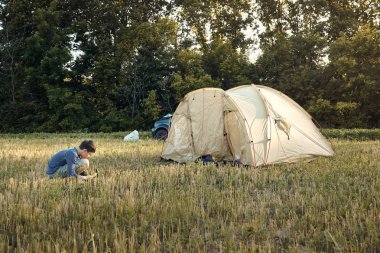 Aile gün batımı, güzel yaz manzara çadır kampı kurmak. Turizm, doğa yürüyüşü ve seyahat.